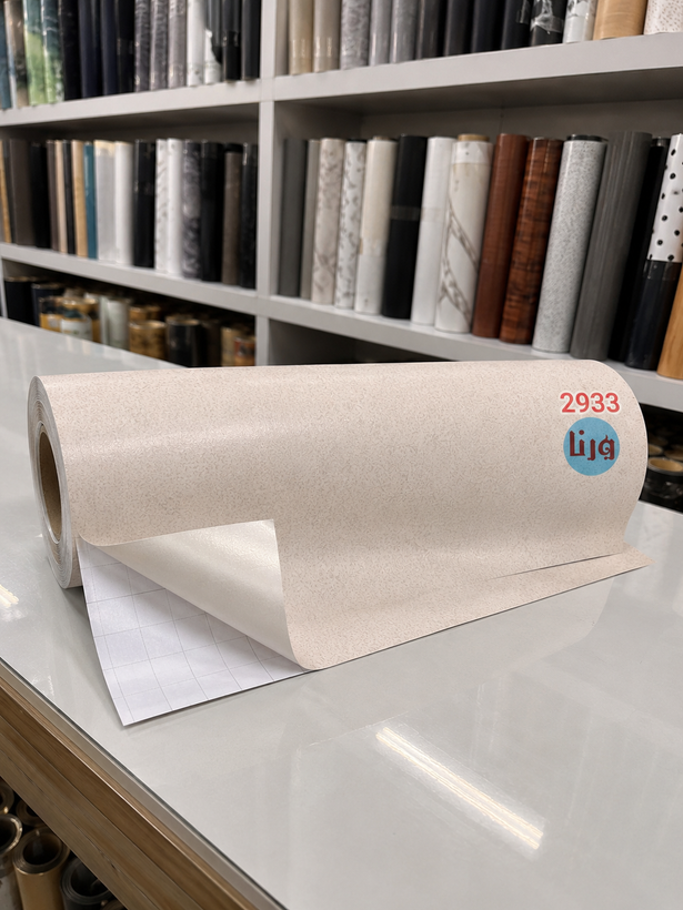 رول افقی برچسب کابینت سنگ کورین یونیک کد ۲۹۳۳ روی میز به همراه کاغذ محافظ شطرنجی پشت کار جهت نصب راحت