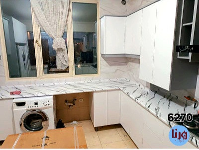 اجرای برچسب طرح سنگ سفید با رگه های منظم مشکی روی صفحه کابینت